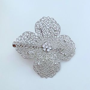 Lacy silver metal flower hair clip with rhinestones.